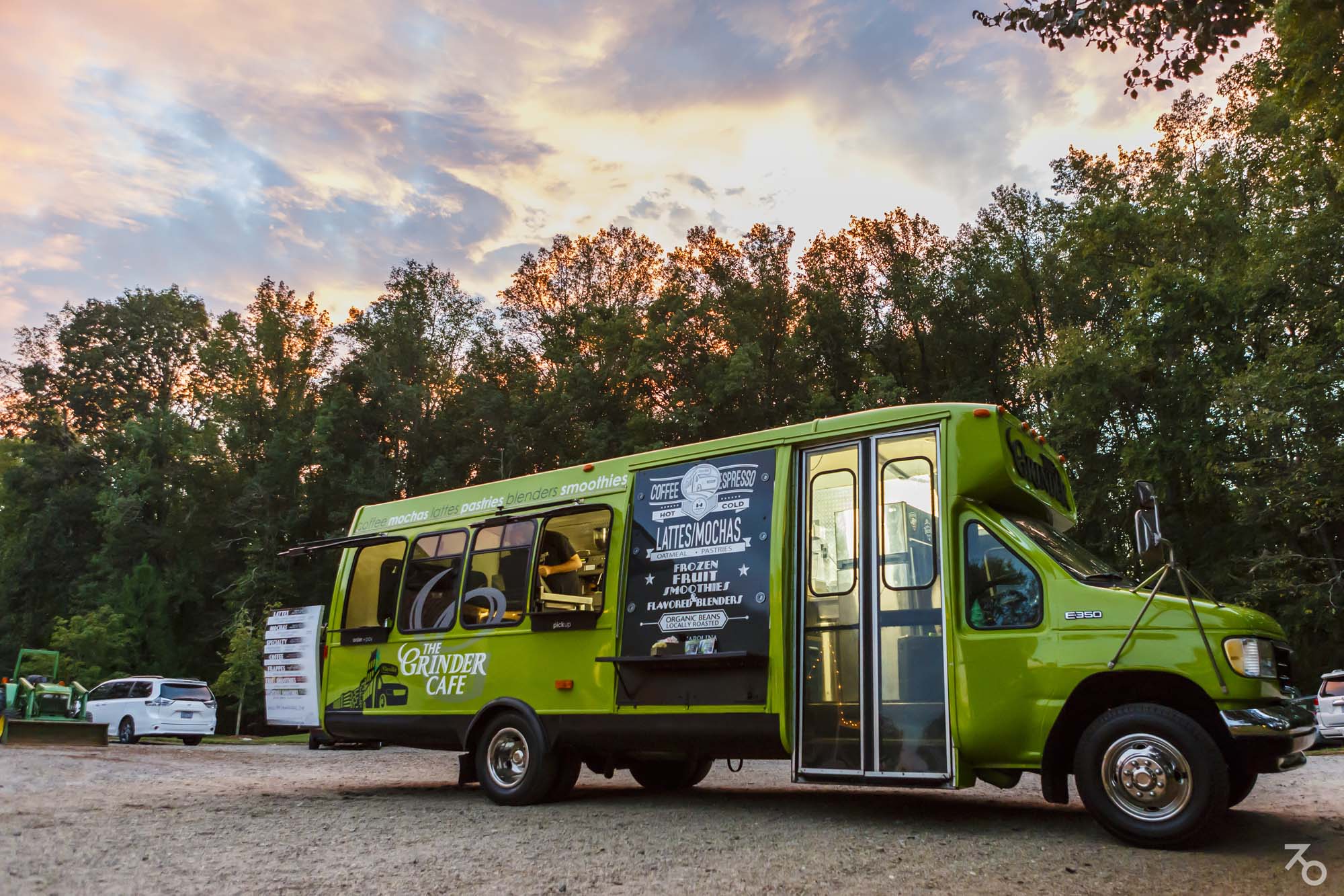 The bright green Grinder Café coffee truck at sunset